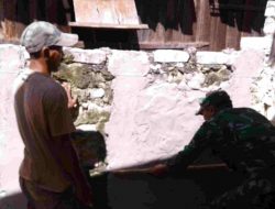 Babinsa Lobuk Melaksanakan Komsos Dengan Membantu Pelepokan Pagar Rumah Warga