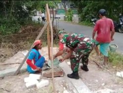 Babinsa Raas Bantu Warga Bangun Dinding Jembatan di Desa Brakas
