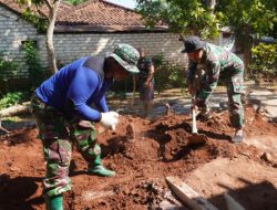 Anggota Satgas TMMD Membersihkan Tanah Bekas Galian Septic Tank